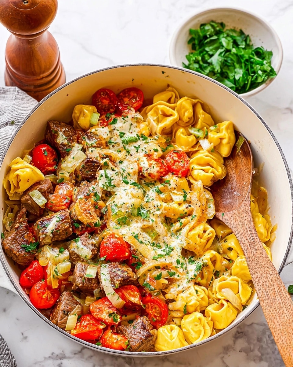 A large white pan is filled with three main layers of food: the base layer is yellow tortellini pasta, soft in texture with a smooth surface; scattered on top are chunks of browned beef, pieces of cooked white onion, and halved cherry tomatoes with a bright red color and slightly wrinkled skin; the top layer has a creamy herb sauce drizzled unevenly with green flecks, some small chopped green cucumber pieces, and sprinkles of fresh chopped parsley. A wooden spoon is partially dipped into the pan from the right side. In the background, there is a small bowl with green leafy parsley and a tall wooden pepper grinder, all sitting on a white marbled surface. Photo taken with an iphone --ar 4:5 --v 7