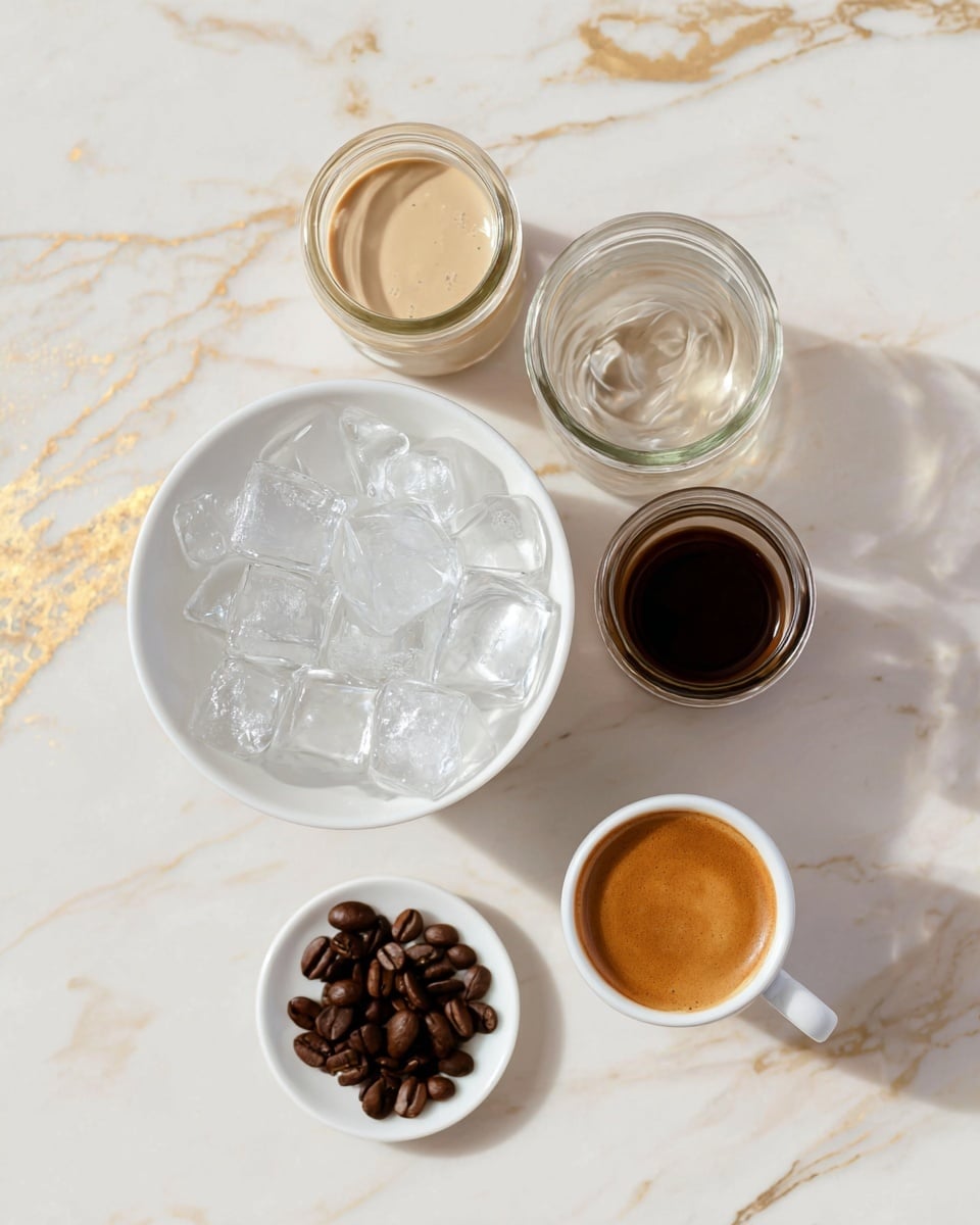 The image shows a white bowl filled with clear, shiny ice cubes on a white marbled surface with gold veins. Above the bowl, there are three small glass jars arranged in a row: the left jar has a light beige creamy liquid, the middle jar has a clear liquid with a smooth swirl, and the right jar contains a dark brown liquid. To the right of the jars, there is a small white cup filled with espresso, showing its rich, frothy top. Below the cup, a small white plate holds several shiny, dark brown coffee beans. All items are neatly arranged in a well-lit setting. photo taken with an iphone --ar 4:5 --v 7
