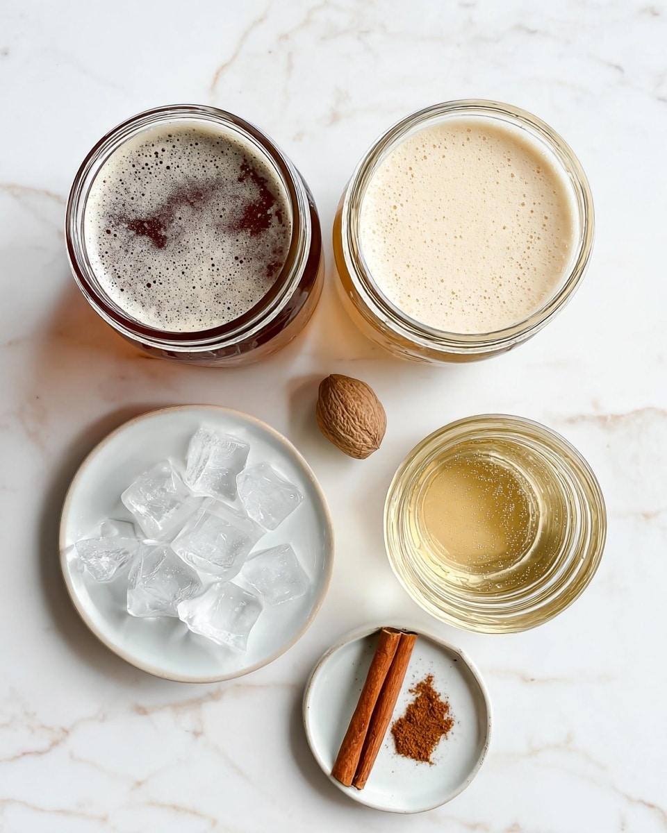 The image shows three glass jars from a top view, each filled with different liquids: one with dark brown beer with foam on the surface, one with creamy light beige liquid, and one with a clear golden sparkling liquid filled with bubbles. Below them, two small white plates are placed on a white marbled surface; one plate holds a cinnamon stick, a whole nutmeg, and a small pile of brown ground spice, while the other is filled with clear ice cubes. The scene is bright and clean, with a smooth white marbled background. photo taken with an iphone --ar 4:5 --v 7