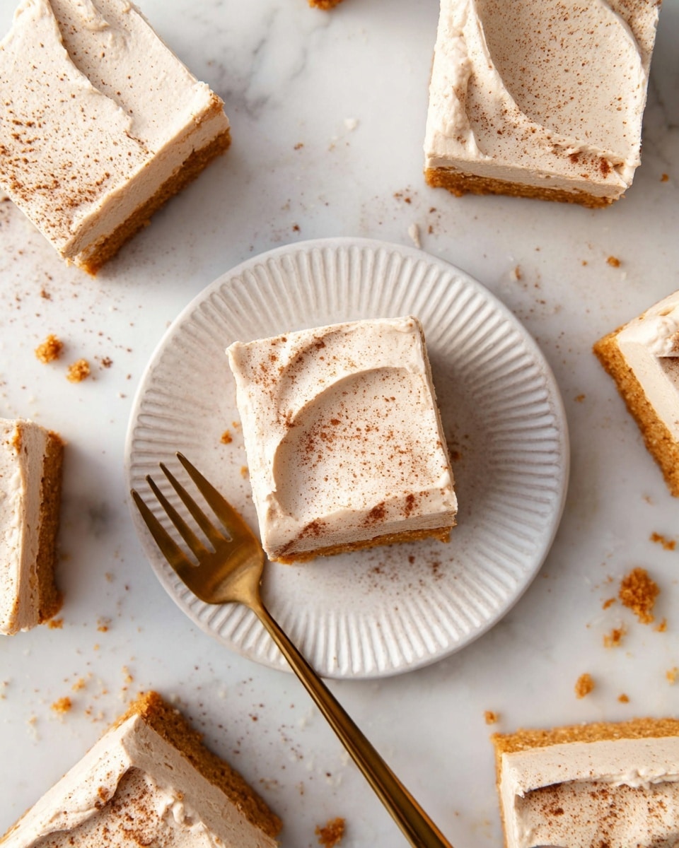 The image shows several square pieces of cake on a white marbled surface, each cake piece with two visible layers: a thick, light brown base and a smooth, light beige frosting layer on top sprinkled with a fine dusting of cinnamon or nutmeg. One cake piece is placed in the center on a white plate with a subtle pattern, and a gold fork rests beside it. Around the plate, there are more cake pieces similarly frosted and sprinkled, arranged casually with a few crumbs scattered on the surface. Photo taken with an iphone --ar 4:5 --v 7