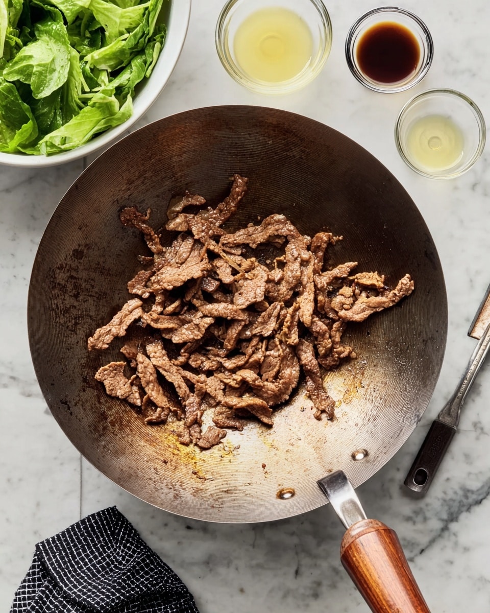 A metal wok with wooden handles holds cooked, thin strips of browned beef with a slightly crispy texture, spread mostly in the center and left side of the pan. The wok is well-used with dark brown and black marks around the edges inside. To the upper left, a white bowl holds fresh green leafy vegetables. Above the wok are two small glass bowls, one with a dark brown sauce and the other with a light yellow liquid. The wok rests on a white marbled surface with a black and white checkered cloth underneath the right handle. Photo taken with an iphone --ar 4:5 --v 7