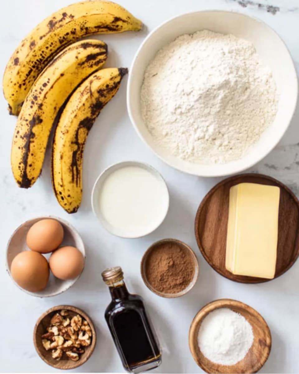 The image shows several bowls and items arranged neatly on a white marbled surface. At the top center, there is a white bowl filled with white flour. To the right of the bowl is a stick of butter. Below the flour bowl and slightly to the right, there is a small white bowl with white liquid. Below that is another small white bowl with two brown eggs. On the left side, there are three ripe bananas with brown spots lying next to a dark bottle of vanilla extract. At the bottom, there is a small bowl with chopped nuts and beside it, another small bowl with two different brown powders, likely spices. A small wooden bowl with white baking powder or soda is also visible near the nuts. The setup is clean with a soft natural light. Photo taken with an iphone --ar 4:5 --v 7