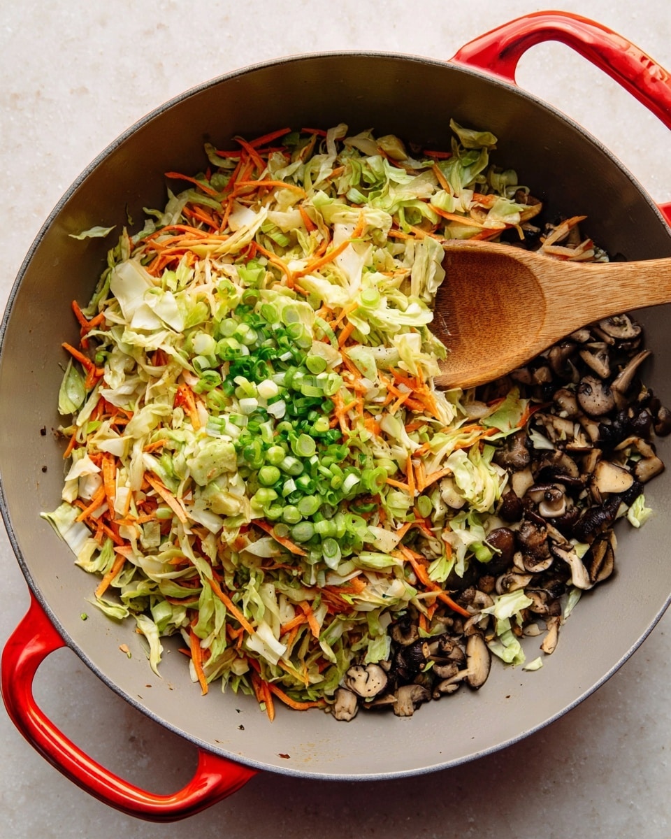 A large grey pan with red handles holds a mix of three main layers of chopped vegetables. The bottom layer is small dark brown mushroom pieces, spread evenly across the pan. Above that is a layer of thin, light green cabbage strips mixed with thin orange carrot strips, creating a soft, shredded texture. Scattered on top and throughout are bright green chopped scallions, adding a fresh pop of color. A wooden spoon rests inside the pan, partially covered by the vegetables. The pan is placed on a white marbled surface. photo taken with an iphone --ar 4:5 --v 7