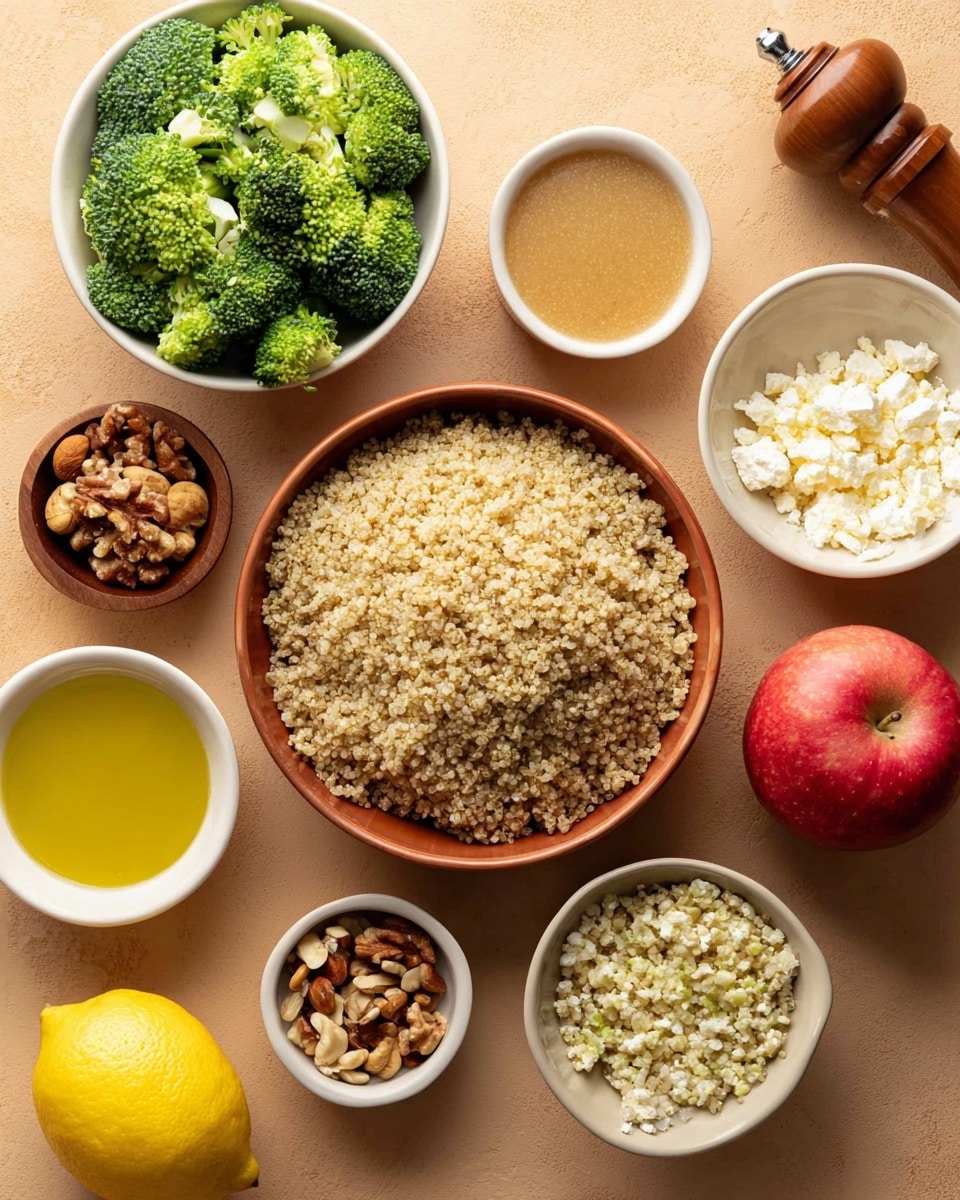 The image shows a top view of a collection of food ingredients on a smooth tan surface. In the center is a large bowl filled with cooked light beige quinoa, its small grains visible and fluffy in texture. Surrounding the bowl are smaller white bowls containing bright green broccoli florets, a mix of chopped nuts with brown and beige tones, crumbled white cheese, and three small bowls of yellow and light brown sauces. On the table are a whole yellow lemon, a red apple, and a brown wooden pepper grinder. The broccoli appears fresh and crisp with a detailed texture. photo taken with an iphone --ar 4:5 --v 7