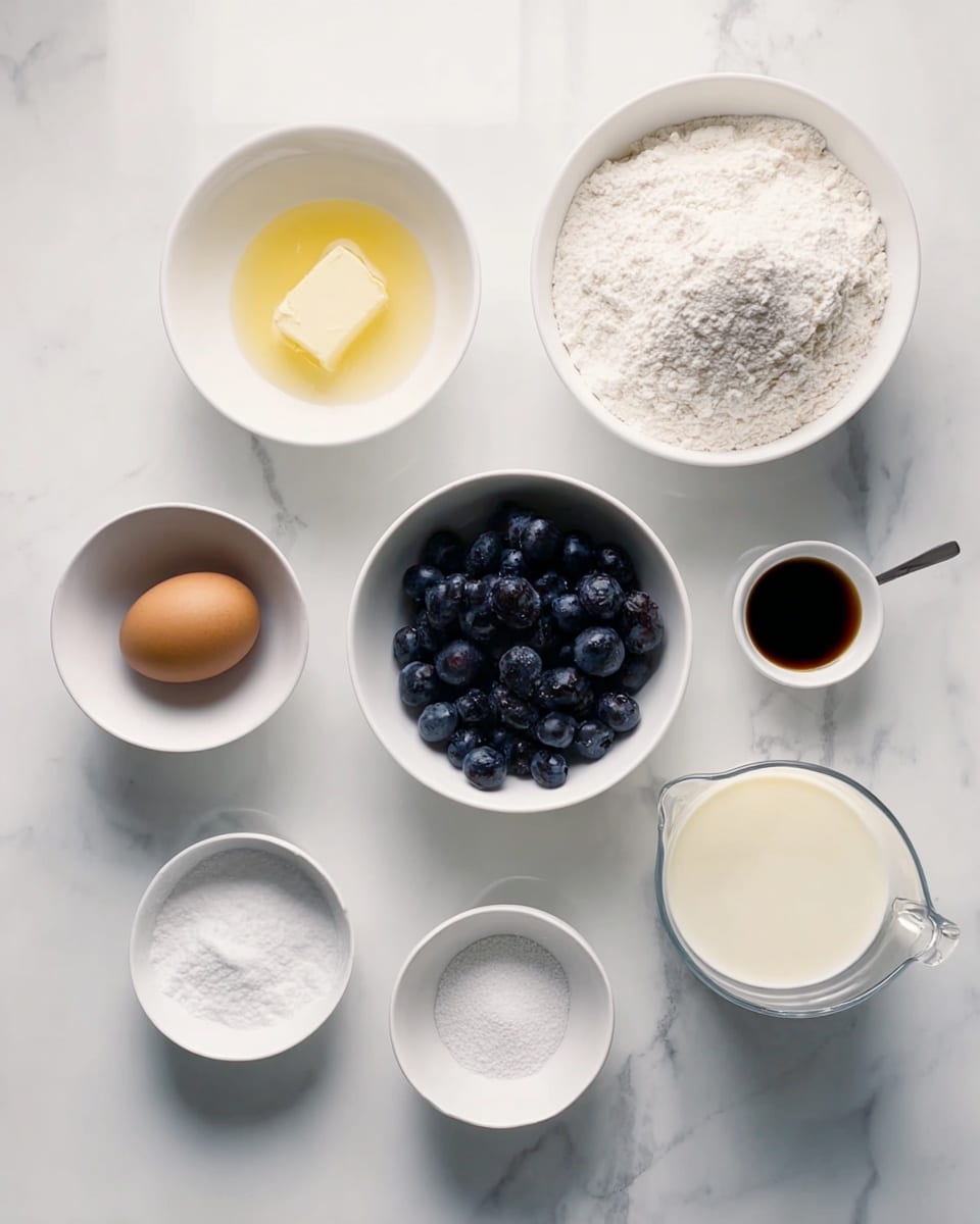 A top view of various baking ingredients arranged neatly on a white marbled surface. There are nine white bowls and a glass measuring cup. From the top left, a large bowl with a small amount of yellowish liquid mix, next to it a large bowl filled with white flour. Below them, a medium bowl with fresh dark blue blueberries on the left, a small bowl with one brown egg in the center, a small bowl with white powder (baking soda and baking powder) to the right, and another small white bowl with brown vanilla extract below. A small white bowl with white granular sugar and a tiny bowl with a white powdery ingredient (possibly salt) sit near the center. On the far right is a clear glass measuring cup filled with milk, and in front of it a small metal cup containing a dark liquid. The setup is clean and organized, with a bright natural light. Photo taken with an iphone --ar 4:5 --v 7