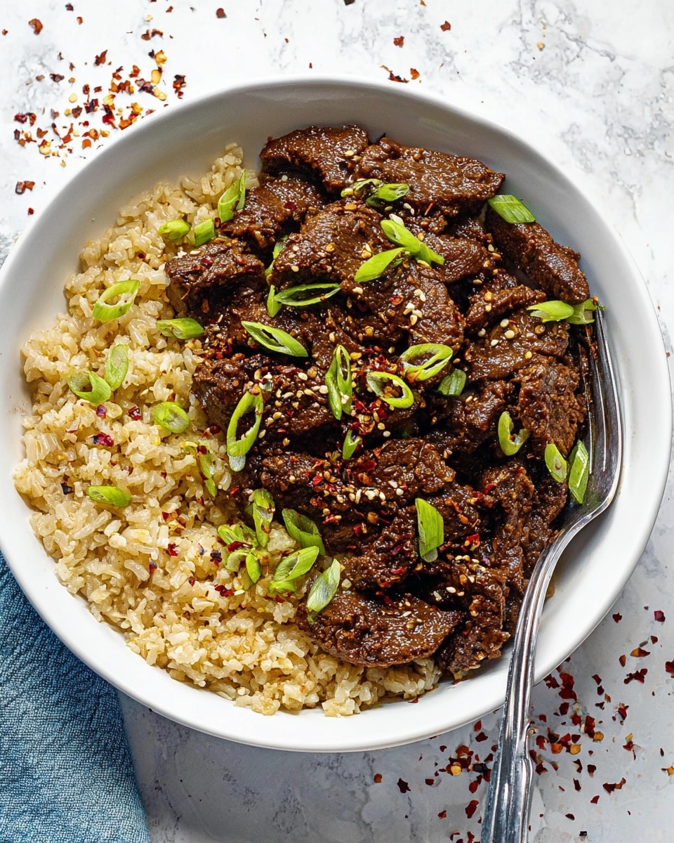 A white bowl filled with two main layers, the bottom layer made of light brown cooked rice with a fluffy texture covering the left half of the bowl, and the top layer consisting of dark brown thin slices of cooked meat piled on the right half and center, all sprinkled with small red flakes and sesame seeds. Bright green slices of scallion are scattered evenly over the meat, and a silver fork is placed on the right side of the bowl, resting inside. The bowl is placed on a white marbled surface with some scattered red flakes around it. Photo taken with an iphone --ar 4:5 --v 7