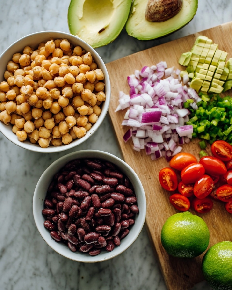 The image shows a white bowl filled with cooked light brown chickpeas and another white bowl filled with dark red beans placed on a white marbled surface. A wooden cutting board rests nearby with layers of chopped ingredients: at the top, a halved avocado with green flesh and a grid pattern on the surface; below it, a layer of chopped purple and white onions; next to it, a layer of finely chopped bright green peppers; and at the far right, halved red cherry tomatoes arranged in a line. Two whole green limes also sit on the white marbled surface near the bowls. photo taken with an iphone --ar 4:5 --v 7