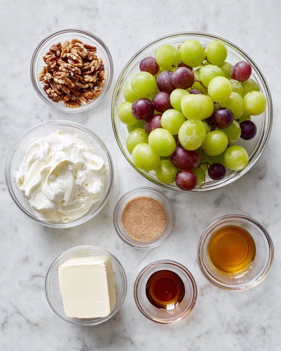 The image shows several small clear glass bowls arranged on a white marbled surface. The largest bowl holds green and purple grapes mixed together in smooth round shapes and shiny textures. Surrounding this bowl are six smaller bowls. One bowl at the bottom holds a smooth, creamy white block of cream cheese. Another bowl nearby contains a fluffy dollop of white whipped topping. A small bowl holds finely chopped pecans with a rough, uneven texture and brown color. One bowl contains light brown sugar in a small pile, while two other tiny bowls hold light amber-colored honey and dark amber vanilla extract, both showing a smooth, liquid texture. The overall scene is clean and simple, showing all ingredients neatly placed for a recipe photo taken with an iphone --ar 4:5 --v 7