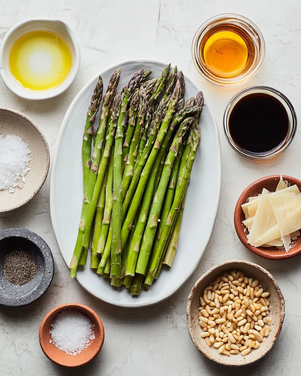 A white oval plate holds about 20 to 25 fresh green asparagus spears, arranged side by side with their tips pointing upward and slightly to the right, showing a textured, slightly purple-green appearance at the ends. Surrounding the plate on a white marbled surface are small white and terracotta bowls with various ingredients: one with light golden liquid near the bottom left, another with white salt crystals at the top left, a dark gray stone bowl with black and white ground pepper just below it, a small clear glass container with dark soy sauce to the top right of the plate, a tiny white bowl containing bright amber liquid under the glass container, a terracotta bowl filled with golden toasted pine nuts to the right of the soy sauce, a small rustic bowl with off-white shaved cheese at the far right, and a small gray bowl with white powder (likely flour) near the bottom right. Photo taken with an iphone --ar 4:5 --v 7