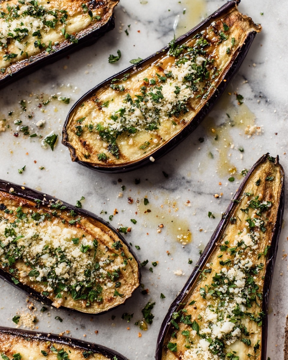 Several slices of roasted eggplant lie flat on a baking sheet lined with parchment paper. Each slice has a dark purple skin around the edges and a creamy off-white inside. The top layer of each slice is sprinkled with a mix of small green herbs and finely grated cheese, which has baked to a golden brown in spots, giving a slightly crispy texture. The eggplant slices are moist, with some oil glistening around them on the parchment. The baking tray has light browning and seasoning bits scattered throughout. The background is a white marbled surface. Photo taken with an iphone --ar 4:5 --v 7