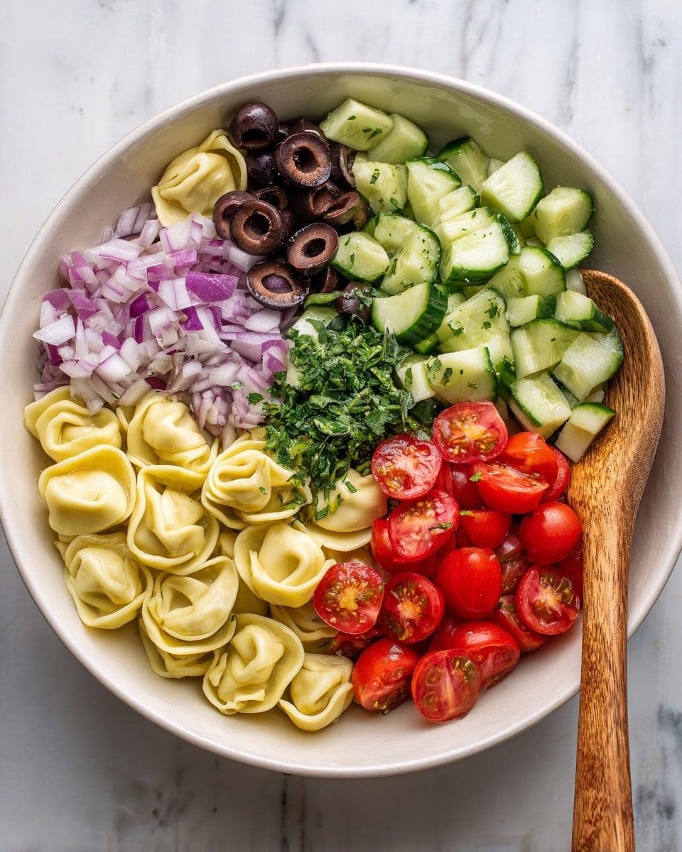 A white bowl filled with a colorful layered salad sits on a white marbled surface. The base is pale yellow tortellini. On top, there are five distinct sections: black sliced olives on the left, finely chopped light purple onions in the center, dark green chopped herbs on the upper right, light green sliced cucumbers next to the herbs, and bright red halved cherry tomatoes on the lower left. A wooden spoon rests on the right side inside the bowl, slightly touching the cucumbers. Photo taken with an iphone --ar 4:5 --v 7
