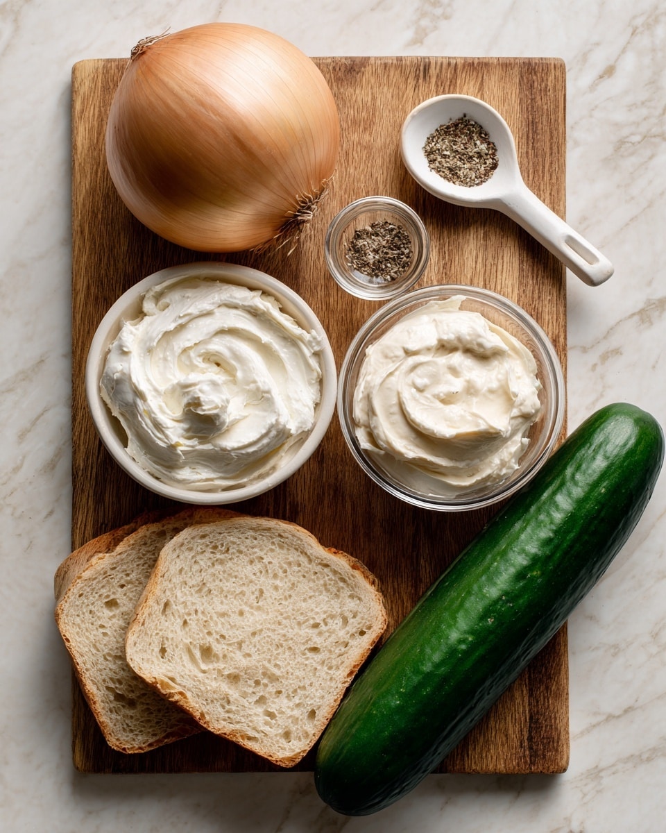 A wooden cutting board on a white marbled surface holds several ingredients: at the top left, a whole light brown onion with smooth skin; to the top right, a white spoon with coarse salt and black pepper; in the center, a small clear glass bowl filled with white vegan mayo with a creamy texture; below that, a white bowl filled with smooth white vegan cream cheese; along the bottom left is a slice of light beige bread with visible soft holes; and diagonally from bottom left to top right is a long, dark green English cucumber with a slightly ribbed texture. Photo taken with an iphone --ar 4:5 --v 7