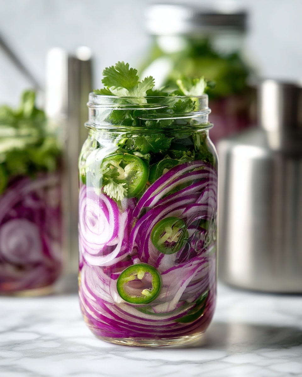 The image shows a clear glass jar filled with layers of thinly sliced purple onions, green jalapeño slices, and fresh green cilantro leaves. The onions form the base and are visible around the edges inside the jar, with jalapeño slices mixed in the middle and cilantro leaves mostly at the top and throughout, giving a fresh, leafy look. The jar is set on a white marbled surface and there is a blurred second jar with similar contents in the background, along with some shiny metal containers. The whole scene is bright and clean. photo taken with an iphone --ar 4:5 --v 7