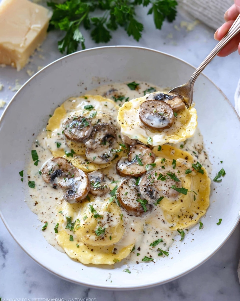 Inside a round pan, there is a creamy white sauce with a smooth and thick texture. Large yellow ravioli pieces cover the pan, each with a clear round shape and wavy edges. Dark brown sliced mushrooms are spread evenly on top, some partially covered with the sauce while others rest on the ravioli. A dark wooden spoon rests inside the pan on the right side, partly dipped in the sauce. Small green parsley leaves scatter lightly on a white marbled surface around the pan, adding a fresh touch. Photo taken with an iphone --ar 4:5 --v 7