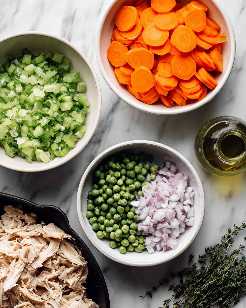 The image shows four white bowls arranged on a white marbled surface, each filled with different chopped or sliced ingredients. The top bowl holds thinly sliced bright orange carrots, neatly stacked and layered. To the left, there is a bowl filled with finely chopped light green celery pieces. Below that, another bowl contains frozen dark green peas with a frosty texture. On the right, a smaller bowl is filled with finely chopped pale purple and white onions. Partially visible is a black skillet or dish on the lower right corner, filled with shredded light tan cooked chicken. Fresh green herb sprigs and a glass bottle with a greenish liquid are also present on the marbled surface. photo taken with an iphone --ar 4:5 --v 7