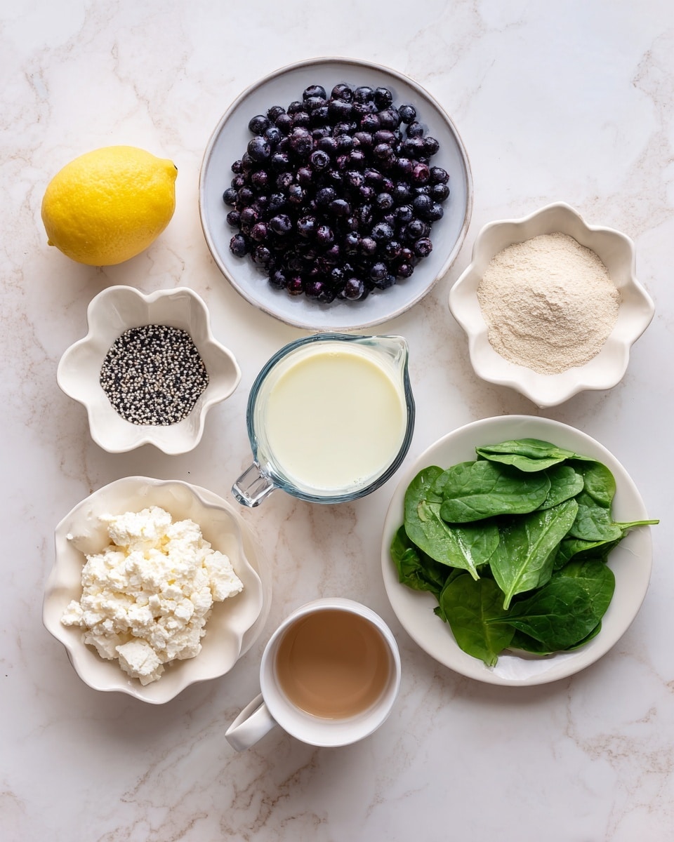 The image shows a collection of ingredients arranged on a white marbled texture. There is one half of a yellow lemon at the top left. Below the lemon is a white plate filled with dark purple blueberries. To the right of the blueberries, there is a white flower-shaped bowl holding light tan powder. A clear measuring cup containing creamy white liquid is placed further right. Below this is another white flower-shaped bowl with small black and white chia seeds. Toward the bottom left, a white bowl holds white cottage cheese. To the right of the cottage cheese plate, a larger white plate has fresh green spinach leaves. At the very bottom, a small white cup contains a light brown liquid. The arrangement is neat and spaced out. photo taken with an iphone --ar 4:5 --v 7