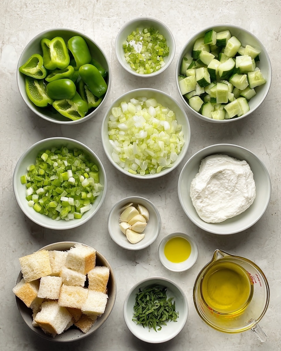 The image shows a top view of several small bowls arranged on a white marbled surface, each holding different fresh ingredients. There are pieces of chopped green cucumber in one bowl, bright green pepper chunks in two bowls, and wedges of green tomato in another. A white bowl holds a thick, creamy white yogurt-like substance, while another bowl contains chopped green onions. A small glass bowl has finely chopped garlic, and a tiny white bowl holds green herb bits. A few bowls are empty or hold small amounts of liquid, including a clear measuring cup filled with golden oil and a small bowl with salt. There is also a larger bowl filled with soft white bread cubes. photo taken with an iphone --ar 4:5 --v 7