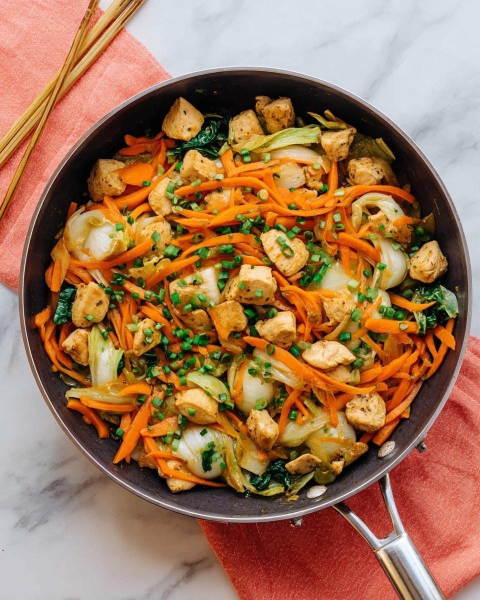 The image shows a pan filled with a colorful stir-fry. The dish has three main layers: bright orange carrot strips, chunks of light brown cooked chicken pieces, and pale green and white bok choy leaves. These layers are mixed evenly in the pan, with small green chive pieces sprinkled on top. The pan is dark with a shiny metal handle and is placed on a white marbled surface. There is also a coral cloth with chopsticks on the surface near the pan. Steam rises gently from the stir-fry, showing it is hot and fresh photo taken with an iphone --ar 4:5 --v 7