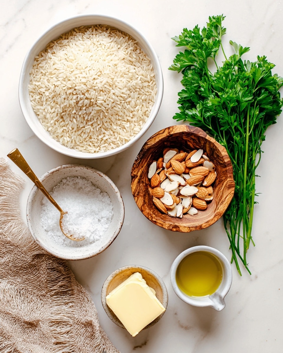 The image shows a close-up top view of a white bowl full of light beige long-grain rice, alongside a white bowl filled with light brown sliced almonds, and a rustic wooden bowl with coarse white salt and a small golden spoon inside. Below these bowls, there is a small white cup with a bright yellow cube of butter, and another small white cup filled with a light golden liquid, likely oil. A bunch of fresh green parsley is placed to the right side, adding a natural touch, on a smooth white marbled surface. A light brown textured cloth is visible on the left side of the frame. Photo taken with an iphone --ar 4:5 --v 7