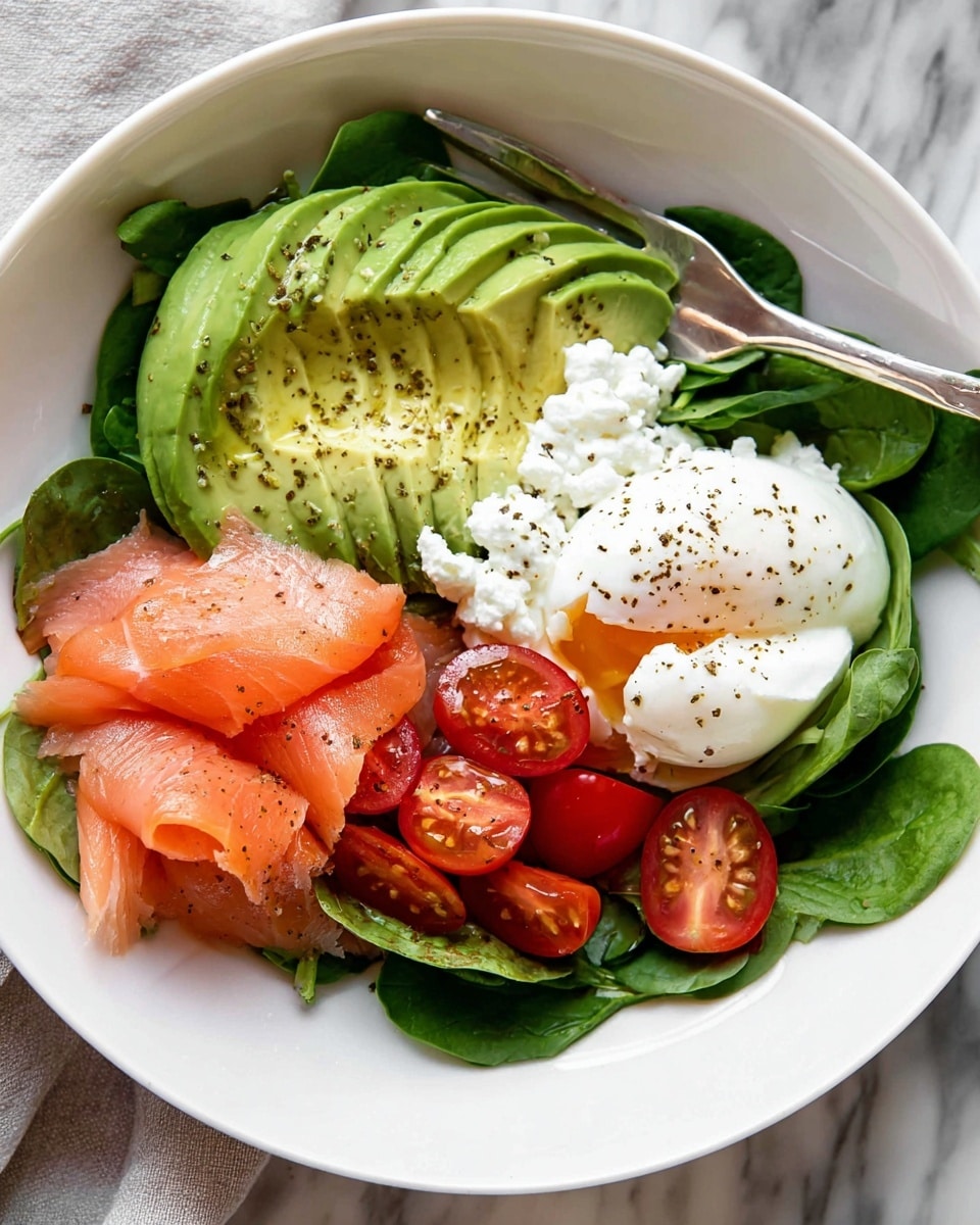 A white bowl filled with fresh green spinach leaves at the bottom, layered with thin slices of light green avocado fanned out on one side, a small pile of pink smoked salmon slices placed next to the avocado, a scoop of white cottage cheese in the center sprinkled lightly with black pepper, vibrant red halved cherry tomatoes beside the cottage cheese, and a smooth white poached egg with black pepper on the side; a silver fork rests on the edge of the bowl, all set on a white marbled surface. photo taken with an iphone --ar 4:5 --v 7