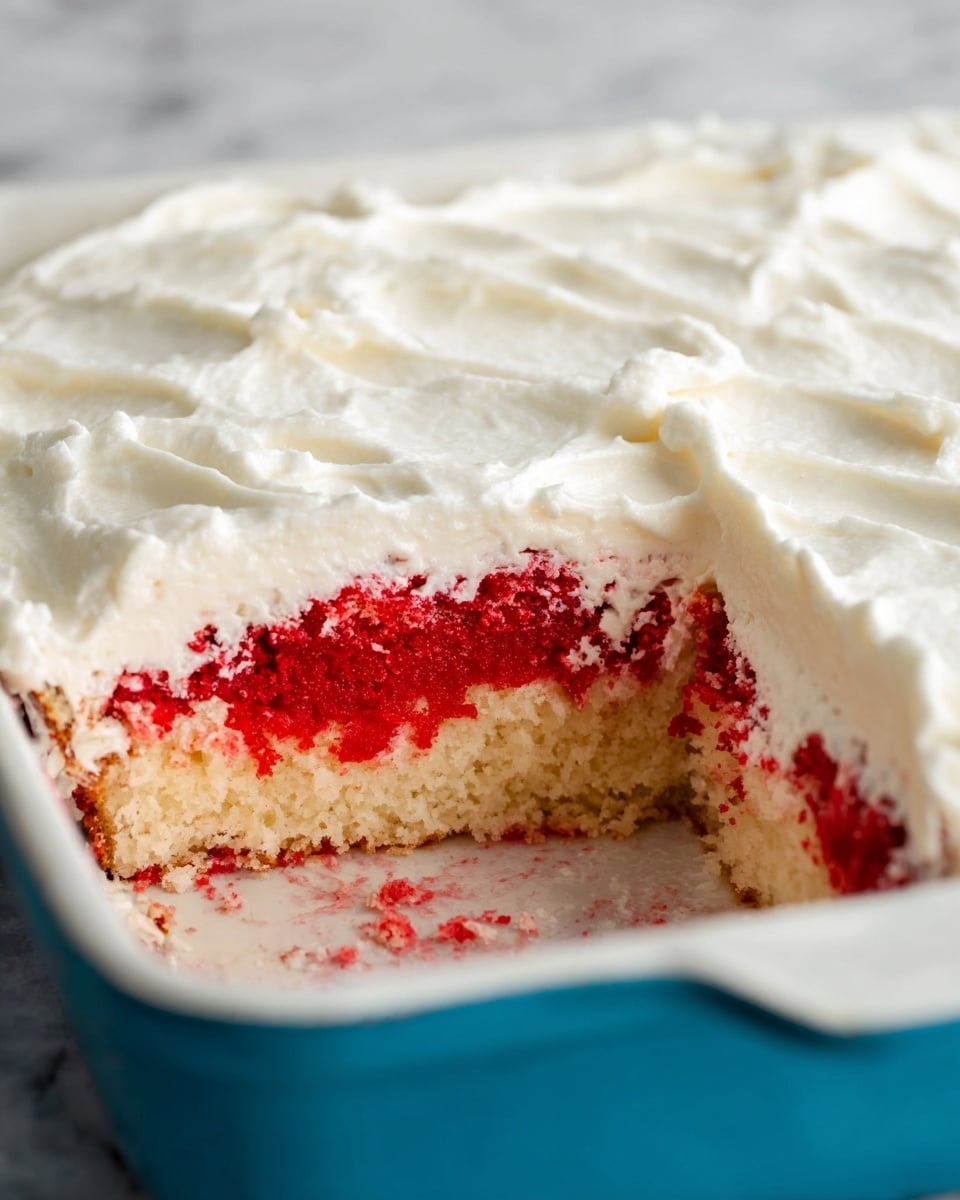 The image shows a close-up of a partially eaten cake in a white baking dish with a blue exterior. The cake has two visible layers: the bottom layer is light beige, and the top layer is bright red with a moist, crumbly texture. The entire cake is covered with a thick, smooth layer of white frosting that has soft, wavy patterns. The dish sits on a white marbled surface. Photo taken with an iphone --ar 4:5 --v 7