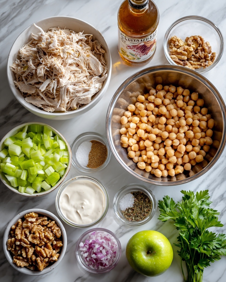The image shows several white bowls and clear bowls arranged on a white marbled surface, each containing separate ingredients for a dish. One large white bowl holds light beige shredded chicken with a soft, fibrous texture. Another large stainless steel bowl holds round, smooth, tan-colored chickpeas evenly spread out. A clear bowl filled with chopped celery shows bright green, crisp pieces cut into small chunks. A small white bowl contains a creamy Greek yogurt dressing layered with beige mustard, white yogurt, and dark seasoning powders. Another small white bowl shows roughly chopped light brown walnuts. Nearby are a whole green apple with smooth skin, a small pile of fresh green parsley, a small white bowl of coarse salt, a small white bowl of chopped red onions with a mix of pink and white tones, and a bottle of apple cider vinegar with a reddish label. Photo taken with an iphone --ar 4:5 --v 7