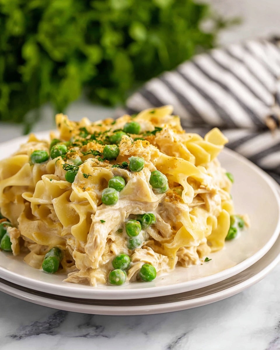A white baking dish filled with creamy macaroni and cheese, topped with a thick, golden brown crumb layer that looks crunchy. Bright green peas are scattered on top and mixed in the pasta, adding pops of color. A woman's hand holds a wooden spoon scooping through the textured topping into the cheesy pasta below. The background includes some green leafy parsley on a white marbled surface photo taken with an iphone --ar 4:5 --v 7