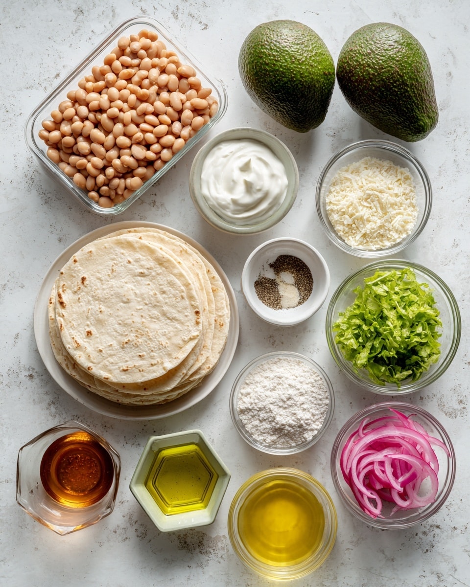 The image shows an arrangement of ingredients on a white marbled surface. In the top left, there is a clear rectangular container filled with light brown refried beans. To its right, two whole dark green avocados with a rough texture lie side by side. Below the avocados, two small clear bowls hold creamy white yogurt and mayo. Under them, a round white plate holds a neat stack of light beige tortillas with soft textures. Next to the tortillas, small clear bowls contain white breadcrumbs and white flour, while a small white dish holds black pepper and salt. A small glass container filled with golden oil is placed near a small bowl of reddish brown adobo sauce. Below these, a small hexagonal glass container shows pale green lime juice. Near the bottom, a clear glass holds a bright yellow egg mixture. To its right, two clear bowls display green leafy toppings and bright pink pickled onions. The setup is clean and well-organized, showing all components clearly for a recipe photo taken with an iphone --ar 4:5 --v 7