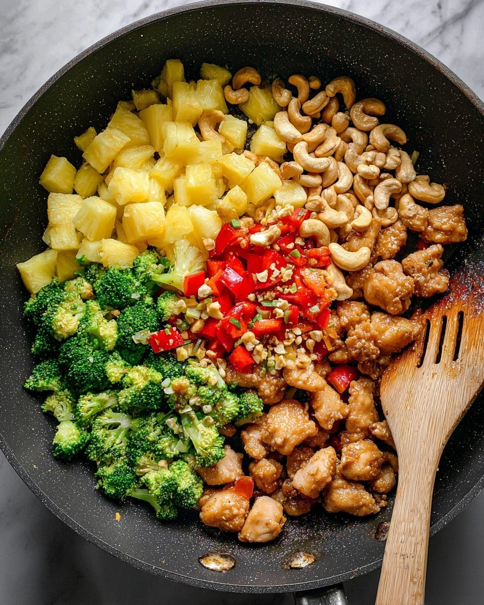 A close-up view of a black pan containing a colorful stir-fry made of four main layers side by side. On the bottom left are bright green broccoli pieces, with diced red bell peppers mixed in. Above the broccoli is a layer of small, light yellow pineapple cubes topped with bits of minced garlic. To the right of the pineapple is a cluster of light brown cashew nuts mixed with some minced garlic. The bottom right layer shows golden brown cooked chicken pieces scattered over more broccoli and red bell pepper, all sprinkled with minced garlic. A wooden spatula with a hole near the top leans against the right side of the pan. The background surface is a white marbled texture. Photo taken with an iphone --ar 4:5 --v 7