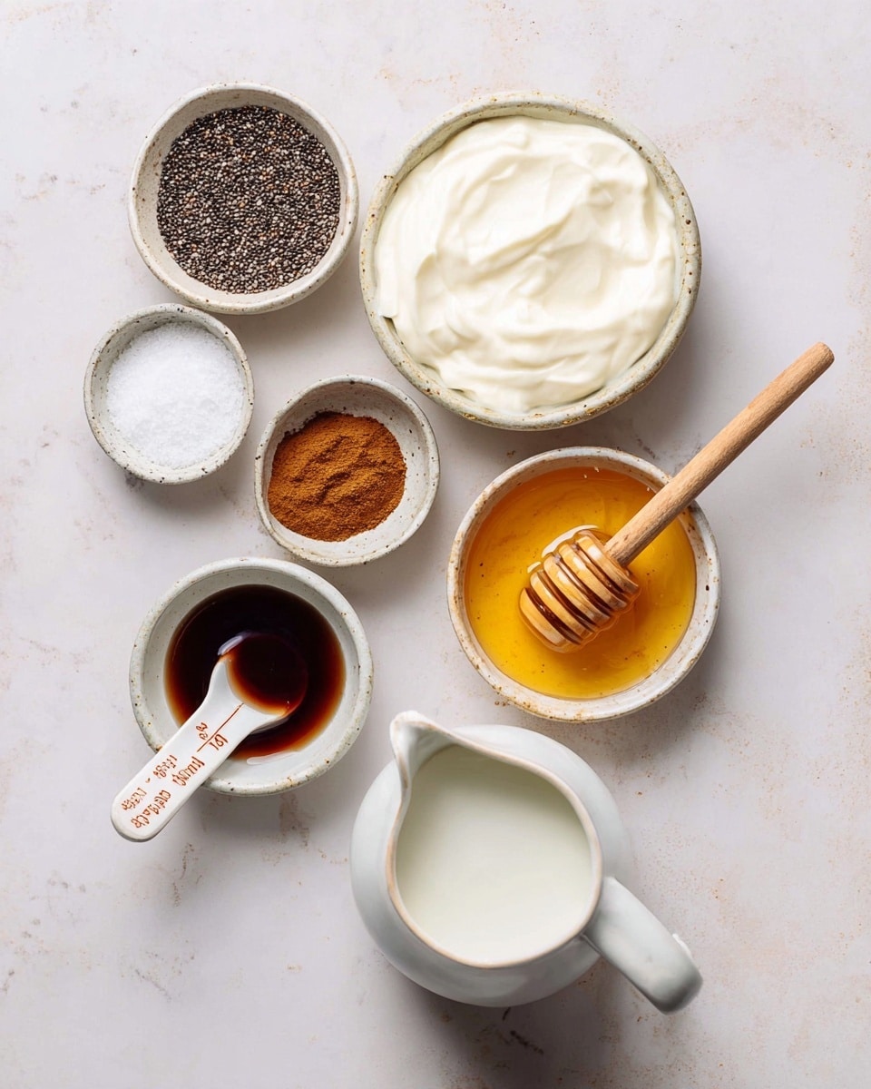 Several small white bowls with different ingredients arranged on a white marbled surface. One large bowl holds smooth, thick white yogurt. Next to it is a bowl with dark brown vanilla extract. Below is a small bowl with light brown cinnamon powder. To the left, there is a bowl with white salt. A larger white bowl contains black chia seeds with a white and terracotta measuring spoon resting on top. On the right side, a clear bowl holds golden honey with a wooden honey dipper inside. At the bottom of the image, there is a white pitcher filled with a white liquid, likely milk. photo taken with an iphone --ar 4:5 --v 7