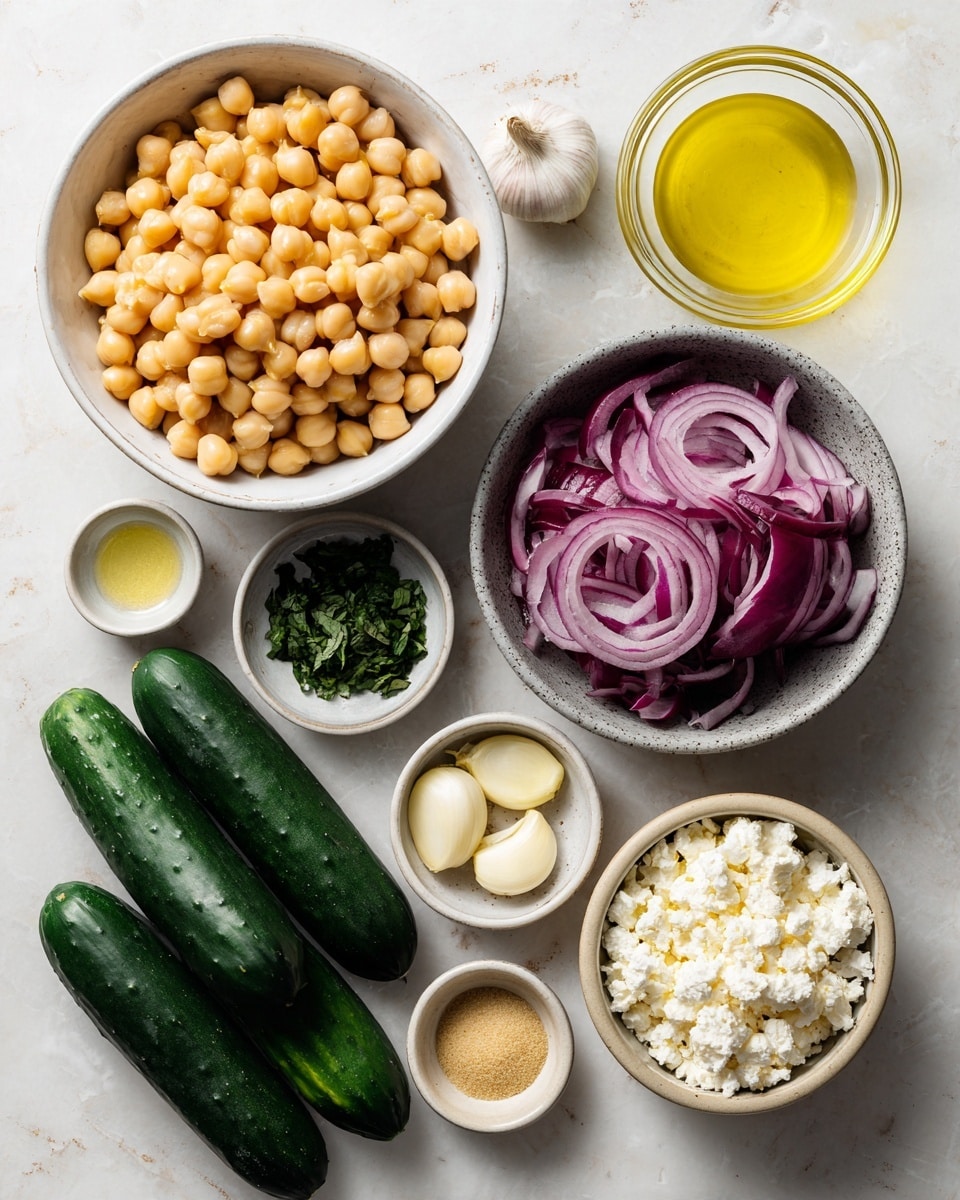 A top-down view of several ingredients on a white marbled surface arranged neatly: a large white bowl filled with light golden chickpeas at the top left, a small clear glass bowl with bright yellow olive oil top right, and a small white bowl with chopped dark green mint leaves beside it. Below these, a small white bowl contains thin purple-red sliced red onion rings, and next to it is a beige bowl filled with crumbly white feta cheese. Near the center, a small beige bowl holds three pale garlic cloves, a small pile of white salt, and a small dollop of light brown dijon mustard. To the left side, there is another small white bowl with light yellow lemon juice and a bunch of long, shiny dark green cucumbers lined up below. photo taken with an iphone --ar 4:5 --v 7