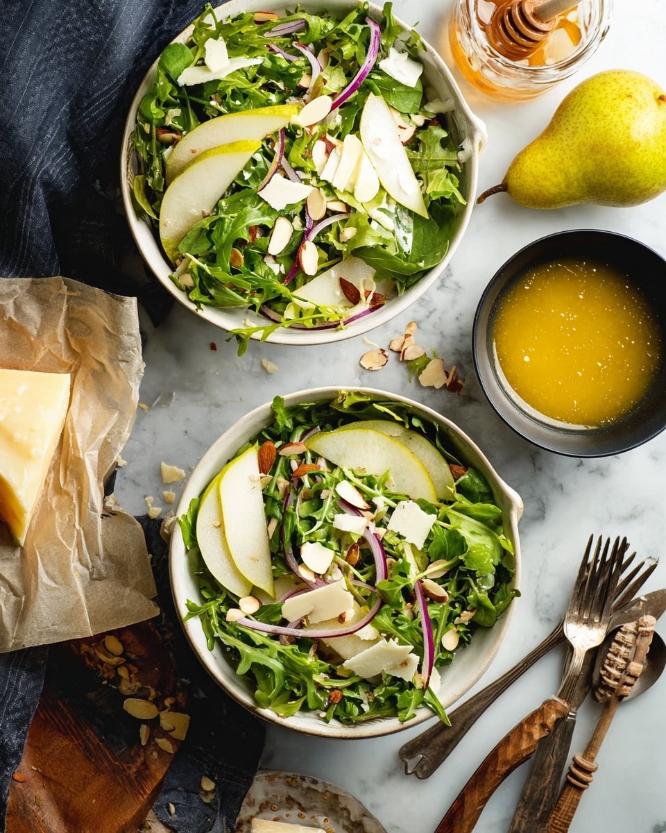 A fresh green salad is shown in a white square bowl placed on a white marbled surface. The salad has three layers: a base layer of bright green spinach leaves, a middle layer with thin white slices of pear, and a top layer of sliced red onions and almond slivers adding texture and color contrast. A woman's hand holds a spoonful of golden yellow dressing right above the salad. In the background, there is a glass jar of honey with a wooden dipper, a light green pear, and a small black bowl with extra dressing, all softly blurred. Photo taken with an iphone --ar 4:5 --v 7