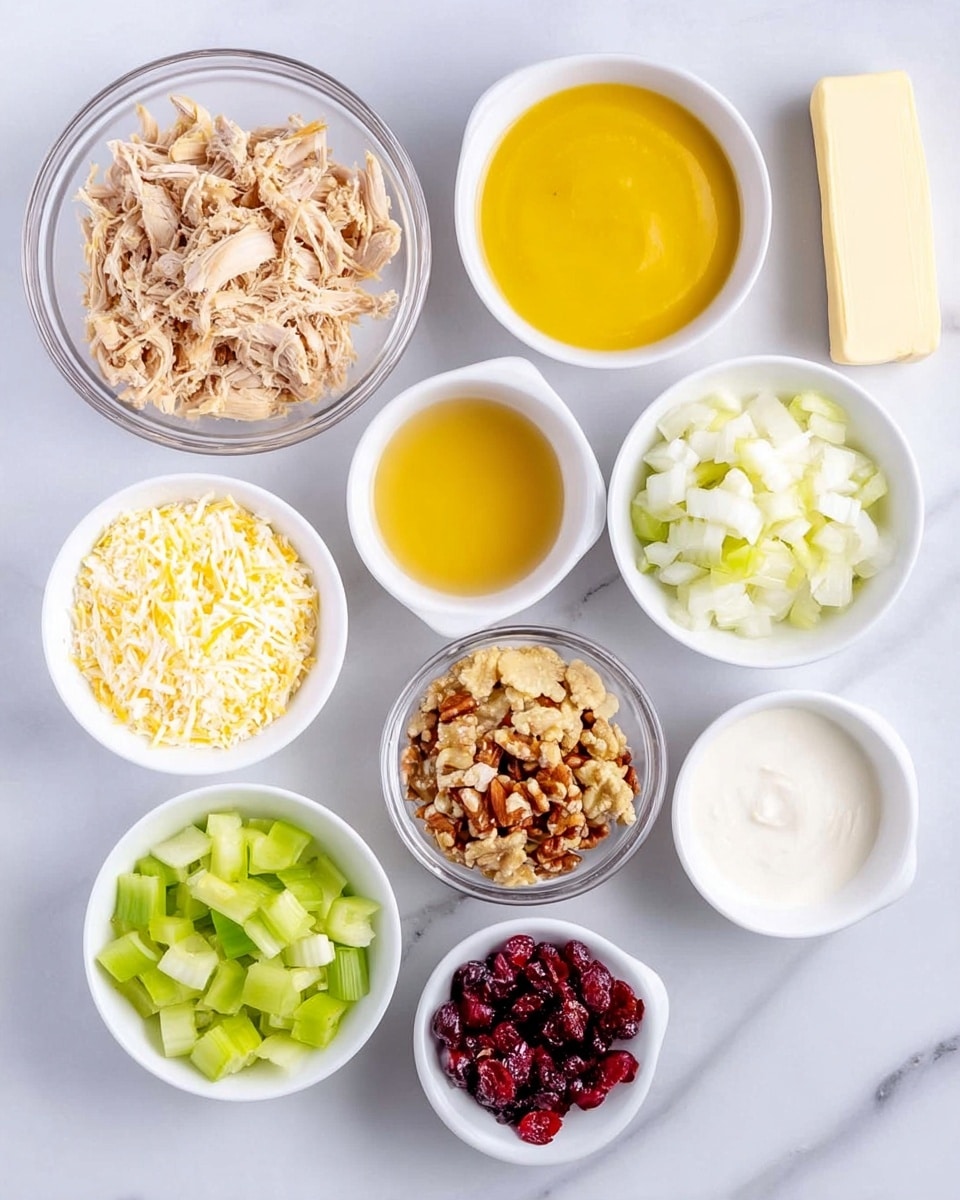 The image shows a group of small white bowls and a clear glass bowl arranged neatly on a white marbled surface. The clear glass bowl on the left holds shredded cooked chicken in a light brown color. To the right, a white bowl is filled with a bright yellow smooth sauce. Next to it, a white bowl contains chopped white onions, followed by another white bowl with a golden yellow liquid. Below these, from left to right, there is a white bowl with finely grated pale yellow cheese, a white bowl filled with crisp green celery pieces, a clear glass bowl containing a mixture of crushed crackers and nuts, and a white bowl with thick white cream. Finally, at the bottom right, two small white bowls hold dried red cranberries and minced garlic mixed with oil. A stick of salted butter is placed above the bowls. The photo taken with an iphone --ar 4:5 --v 7
